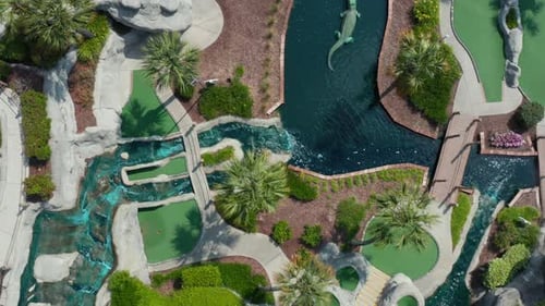 Parcours de minigolf, vue aérienne du haut vers le bas. Amusez-vous en famille sur un parcours de minigolf agrémenté de palmiers et d'un exploit aquatique