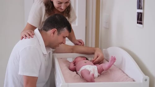 Loving Parents Admire their Newborn Baby at Home