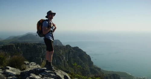 Man, hiker and standing for view, mountain top and peak, adventure and backpack