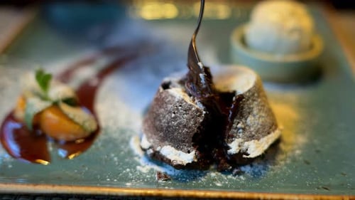 Chocolate lava cake with ice cream and orange decoration in a restaurant