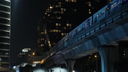 Train dans une ville nocturne moderne sur fond de bâtiments Metro Bts Skytrain Bangkok Thailand