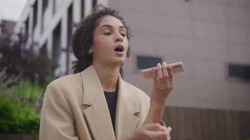 Woman Using Voice Command on Smartphone in City