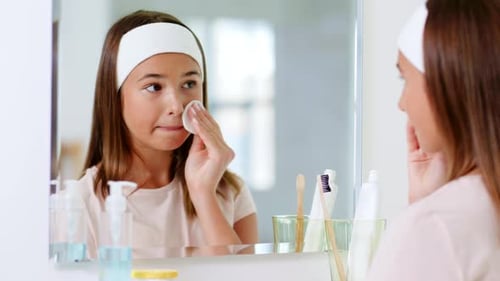 Teen Girl Cleansing Face with Cotton Pad