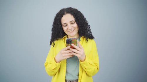 Smiling Woman Using Smartphone on Neutral Background