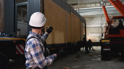 Construction Worker Supervising Prefab Home Loading Process
