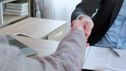 Business Handshake Over a Signed Contract