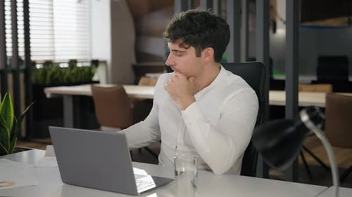 Young Adult Works Diligently at Modern Office Desk