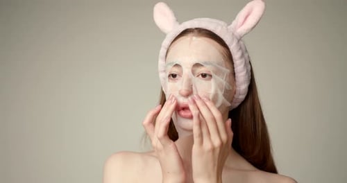 Woman Applies Facial Mask with Pink Headband