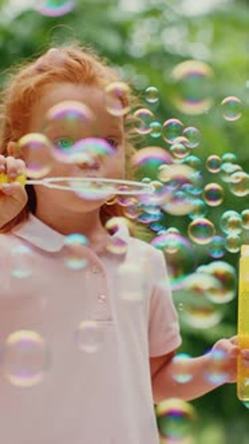 Child Blowing Bubbles in a Sunny Garden During Summer Afternoon