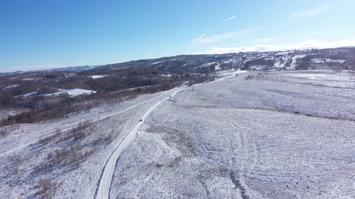 Luftaufnahme des Autofahrens auf einer Winterstraße. Winterliche Landschaft