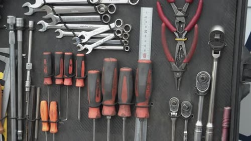 A dolly shot of tools hanging in a tool-case. Screwdrivers, wrenches and pliers.