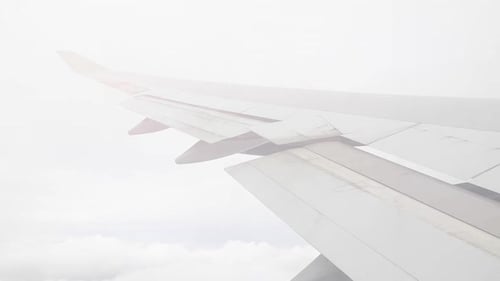 Airplane flying through clouds, over wing window view
