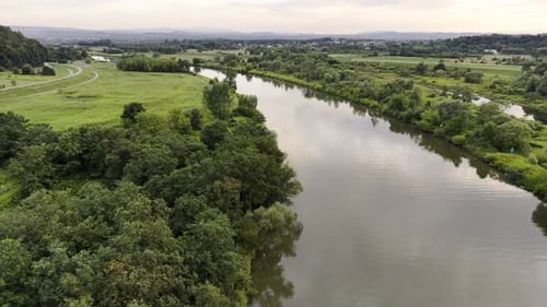 A Drone Gains Altitude Over the River and Flies Along It