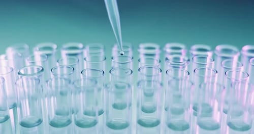 Fluid Being Dropped into Laboratory Test Tubes