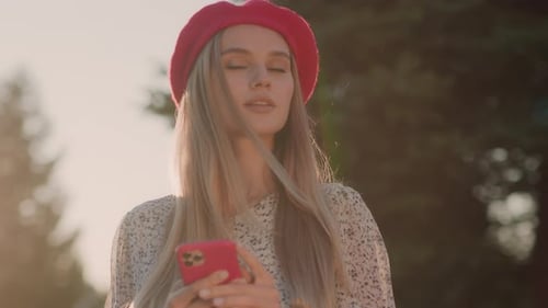 Stylish Woman with Cellphone in Sunny Park