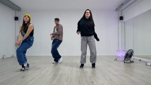 Energetic dancers performing choreography in dance studio