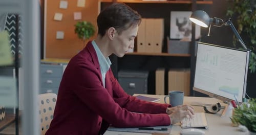 Side View of Male Employee Using Personal Computer Typing Focused on Professional Activity in Office