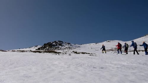Group Of People Hiking In Snowy Mountain