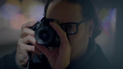 Man With Glasses Taking Pictures at Night