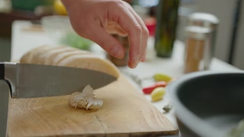 Person Slices Garlic and Adds to Pan