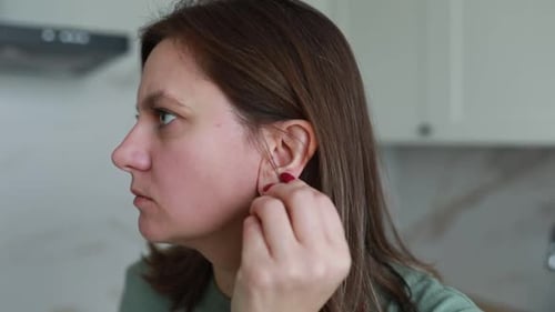 Woman Puts Earring In At Home