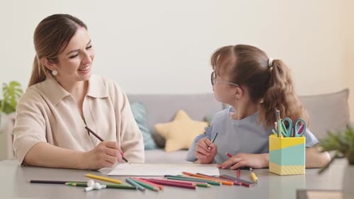 Woman and Child Drawing Together at Table