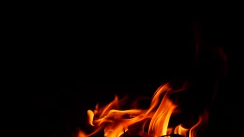 Efecto aleatorio de llama naranja producido por un fuego ardiente en la oscuridad