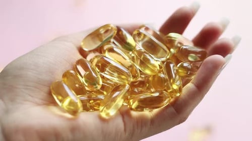 Close-up medicine yellow transparent pills, omega 3 fish oil capsules, vitamin D