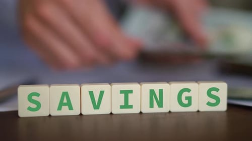 Concept of saving money. Selective focus with person counting cash on the background.