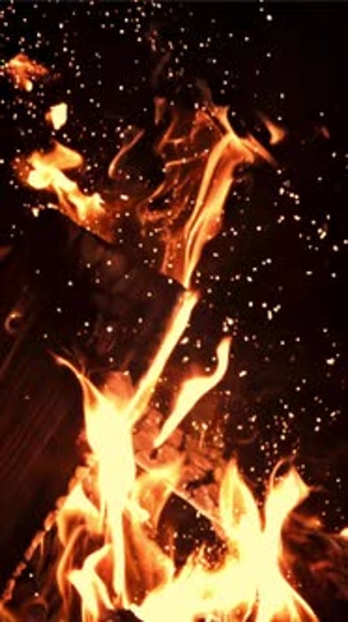 Le bois de chauffage brûle avec des flammes brillantes avec des étincelles filmées au ralenti à 1000 images par seconde