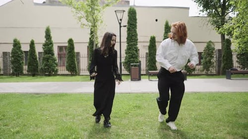 A Couple Enjoys a Romantic Day in a Vibrant Park Dancing Together