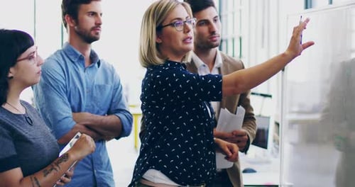 Business Team Collaborating Around Whiteboard in Modern Office