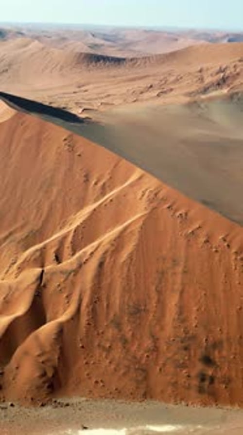 Aerial drone view of endless sand dunes stretching across the Namib Desert creating dramatic pattern