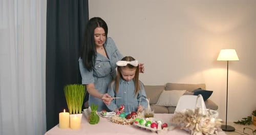 Mother with Daughter Painting Eggs for Easter