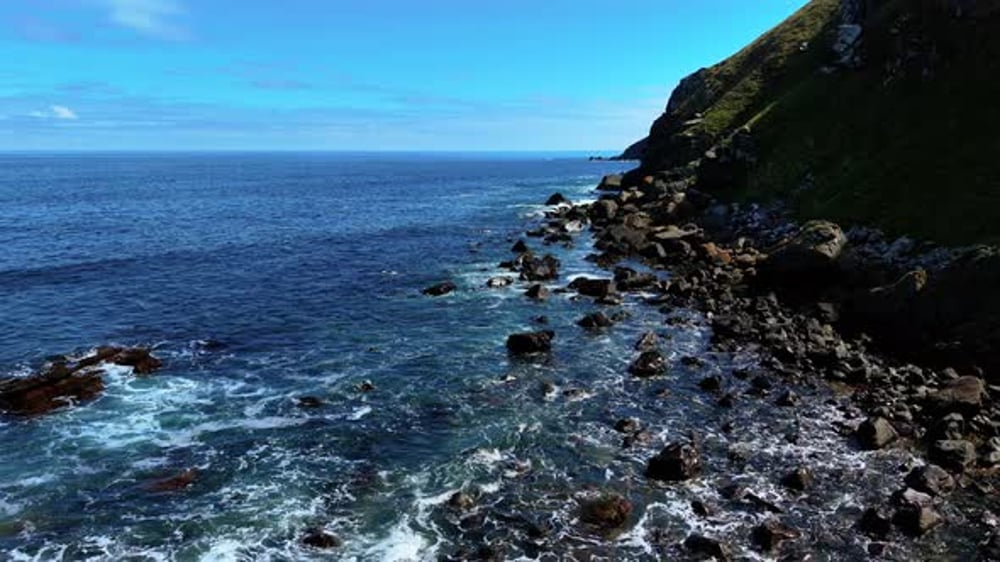 Waves Rolling Over Black Rocks Along Green Hillside Coast Sea Moving ...
