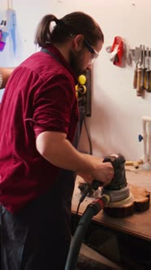 Vertical Video Woodworking Expert in Carpentry Shop Using Angle Grinder to Fix Wooden Surface