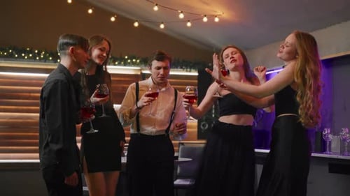 Jovens comemorando o Natal, dançando em boate e bebendo vinho tinto, feliz festa dos melhores