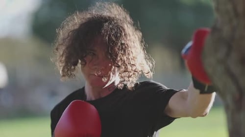 Young Boxer Training Throwing Punches in a Park