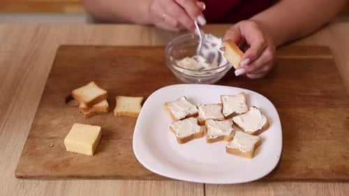 Woman Spreads Cream Cheese on Toast Triangles