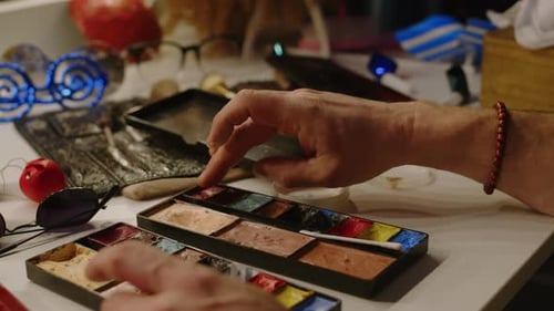 Hands Using Makeup Palette with Cotton Swab