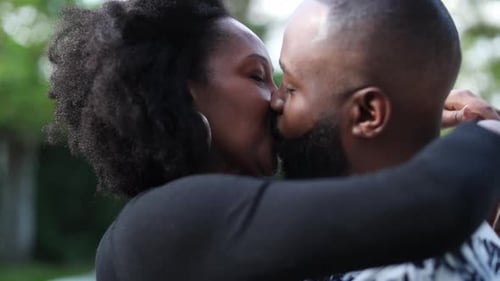 Loving Couple Embraces and Kisses in Green Urban Setting