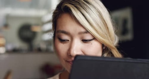 4k video footage of a beautiful young woman using a digital tablet at a cafe