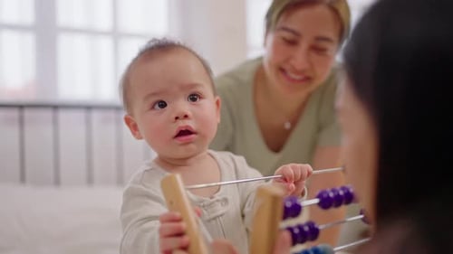 Happy Infant Playing with an Abacus at Home
