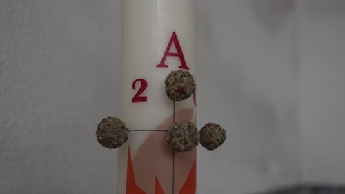 Close-up of a Paschal candle with detailed decorations and symbolic elements.