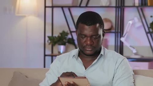 Black Man Working on Digital Tablet from Home