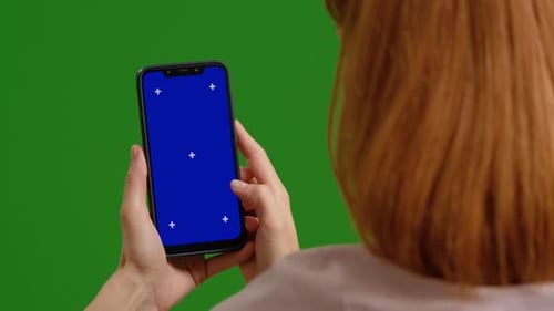Woman phone in hands swipes left and right green blue mock up chromakey screen over green screen bac