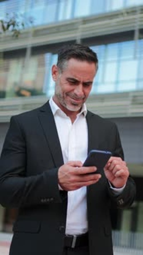 Vertical Portrait of One Businessman Using His Mobilephone Outside Mature Male Browsing Online with