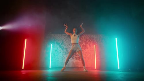Woman Dancing with Neon Lighting in Dark Studio