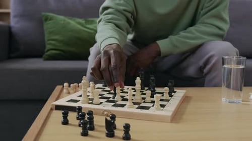Close-Up of Man Playing Chess against Himself during Solo Practice at Home