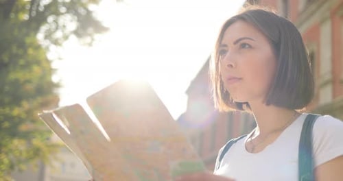 Woman Traveler Reads Map in City Street